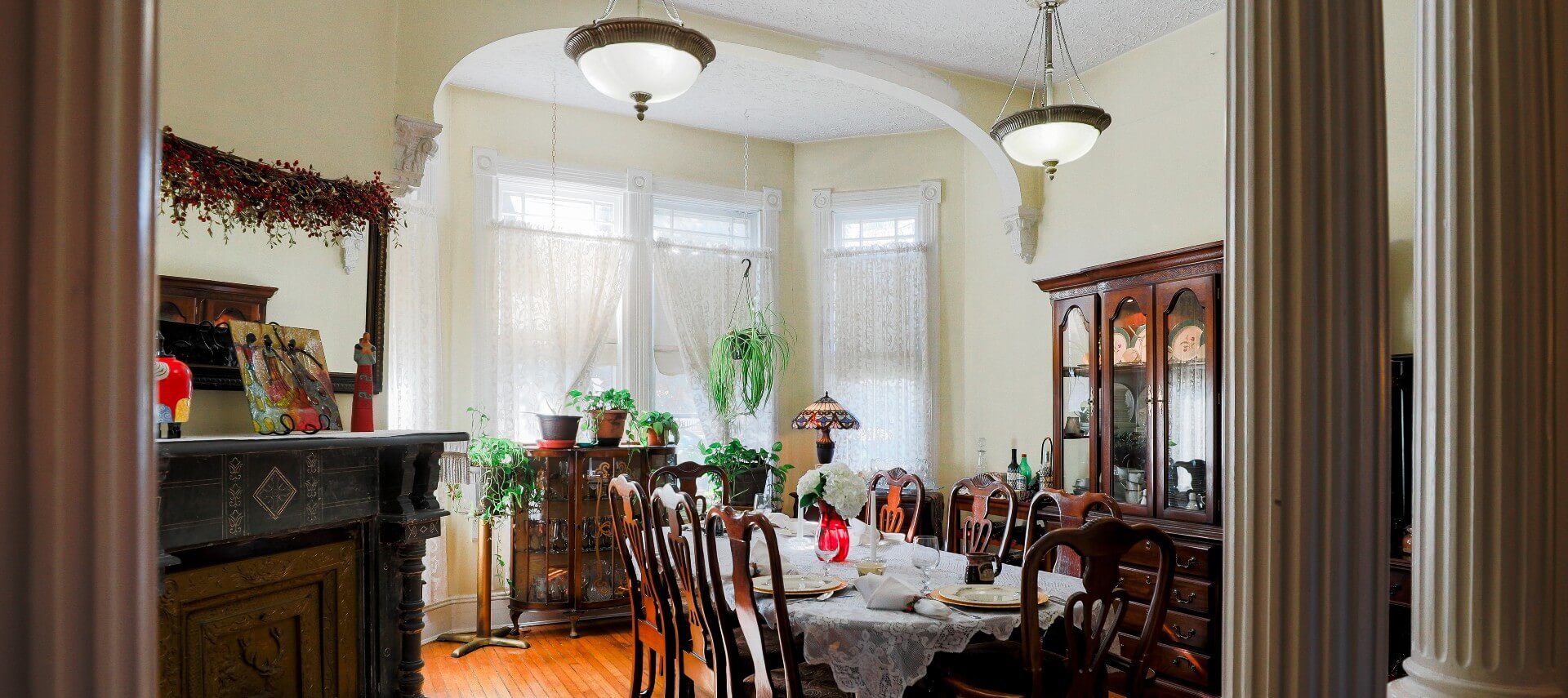 Large dining room with antique table and hutch and bay window with three large windows