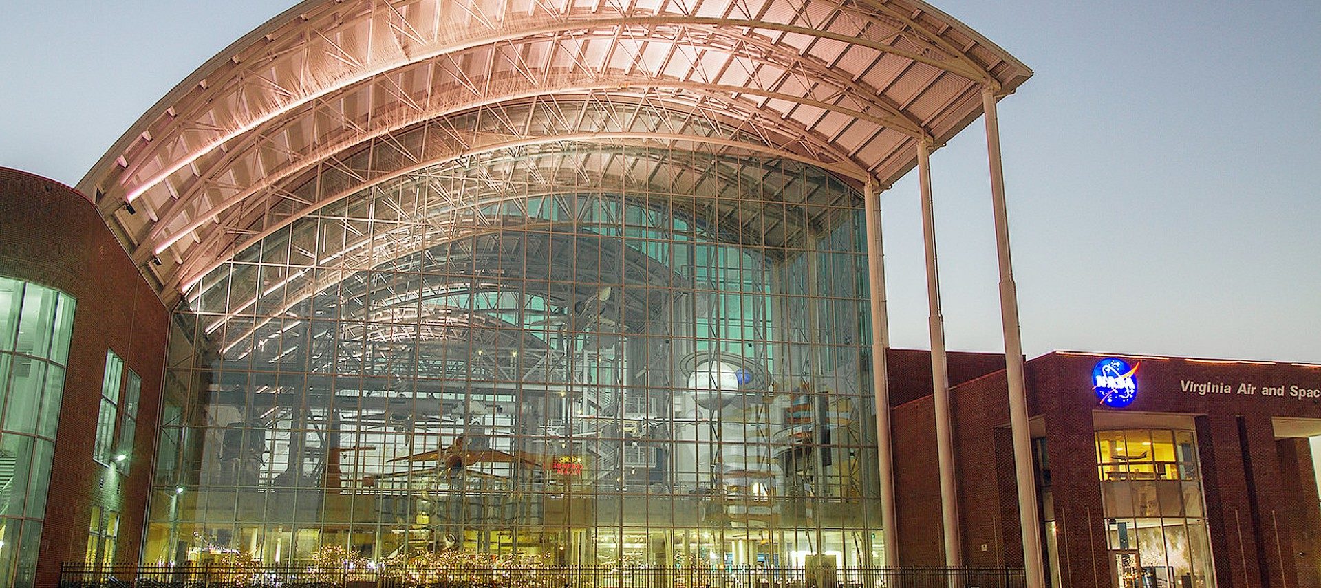 Large Air & Space Museum showing suspended airplane through glass window.